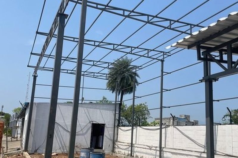 Tubular columns with truss rafters and purlin grid forming a covered handling area