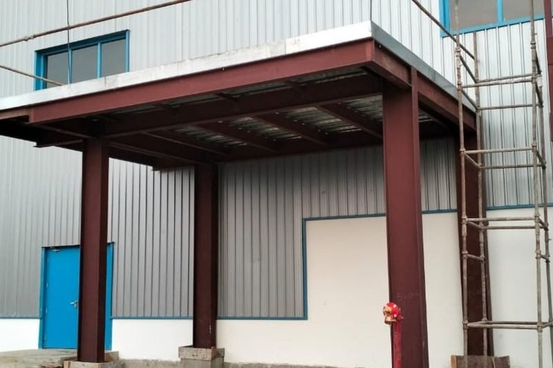Completed clad building with a beam and column canopy over the entry bay