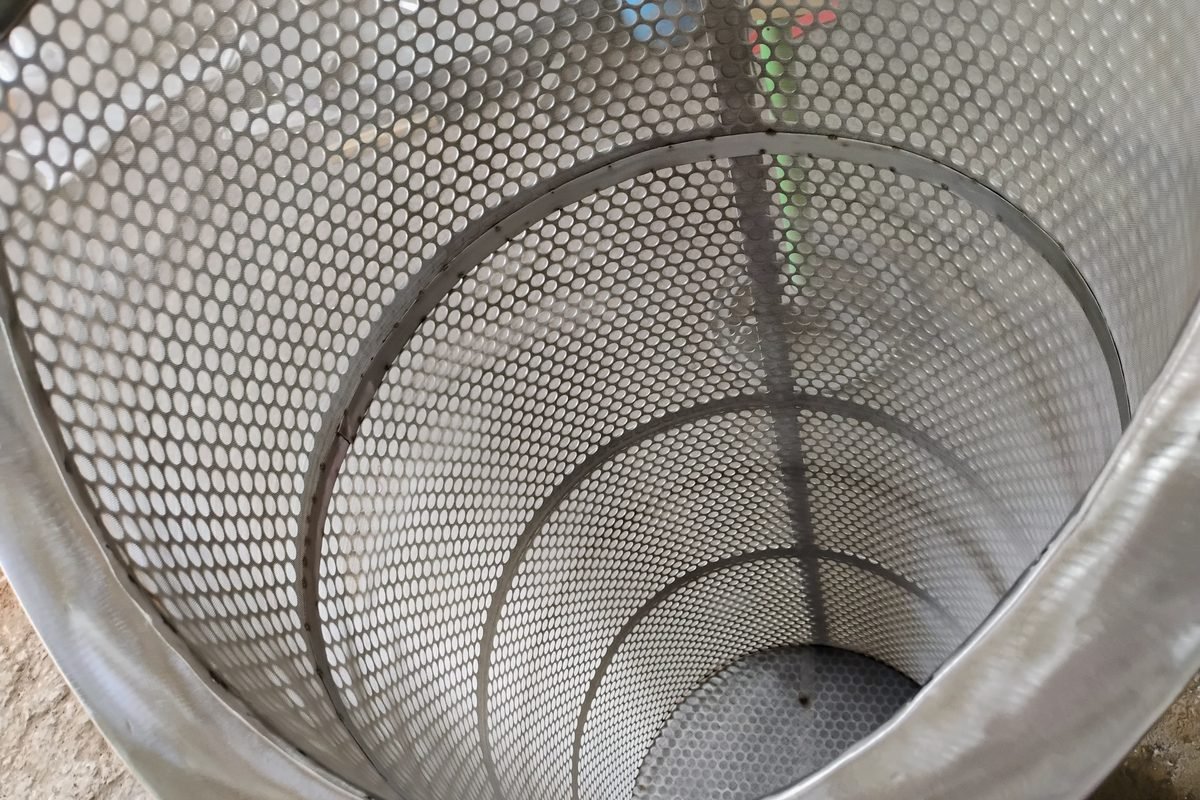 Close inspection of a perforated stainless steel strainer screen element