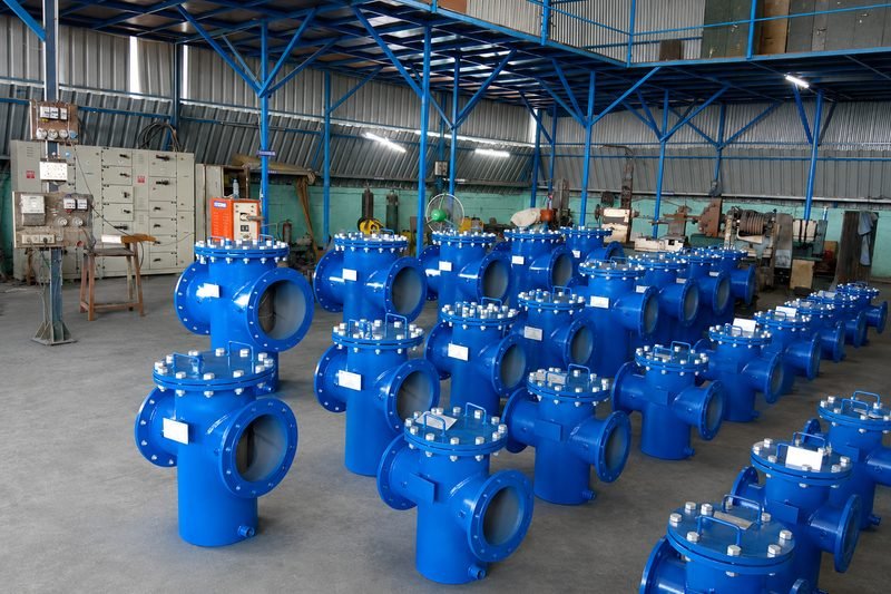 Batch of blue painted basket strainers with bolted covers and lifting handles, finished and tagged on the LKS Industries shop floor