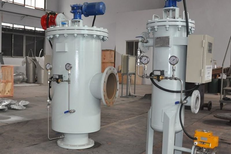 Two automatic self-cleaning strainers with electric actuators and a control panel on the shop floor