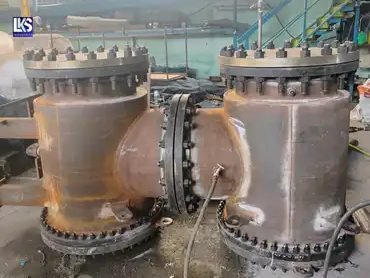 Two heavy fabricated strainer bodies with studded flanges during fabrication